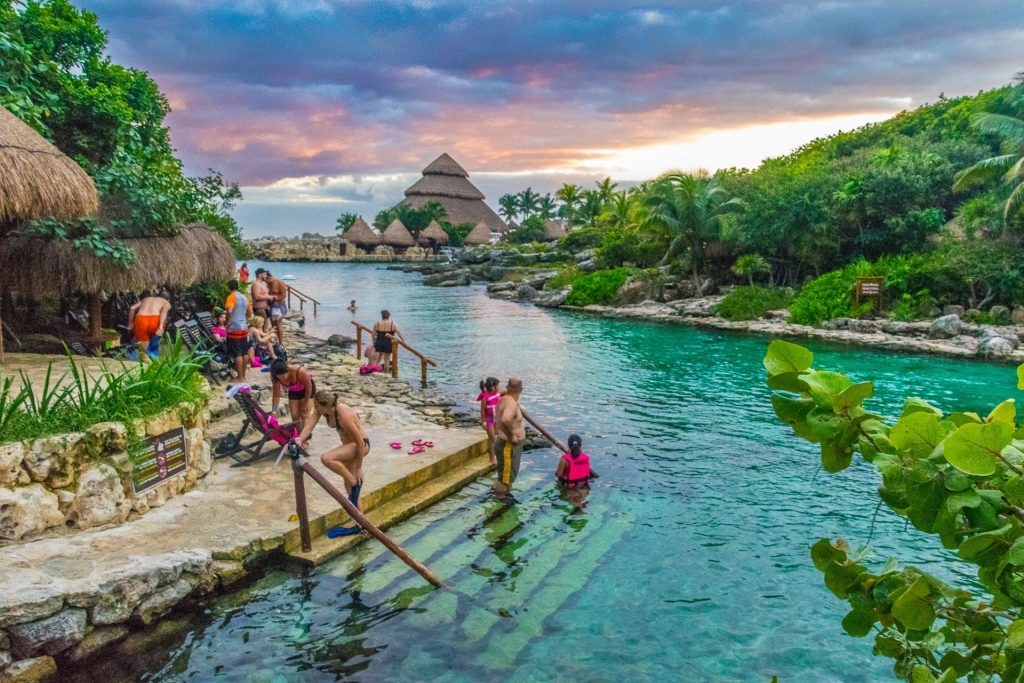 Turquoise lagoon surrounded by lush vegetation inside Xcaret